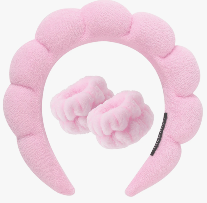Pink plush headband with bow on a white background
