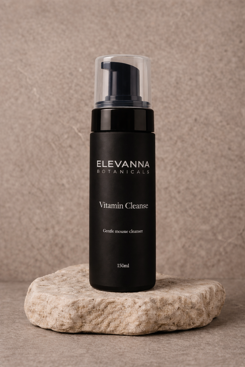 Black bottle of ELEVANNA Botanicals Vitamin Cleanse on a stone surface with a beige background